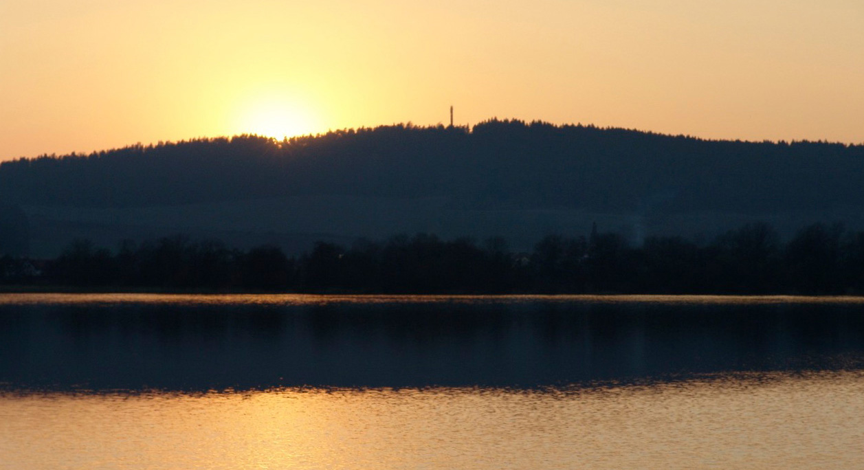 Sonnenuntergang am See mit Blick auf den Riechheimer Berg